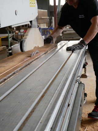 Ein Tischler bearbeitet die Dielen für den erneuten Einsatz. 