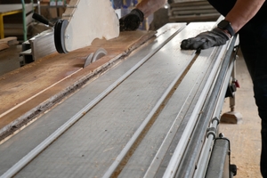  Ein Tischler bearbeitet die Dielen für den erneuten Einsatz.  