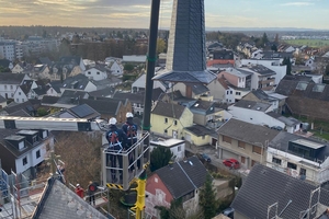  Anschließend wurde die Turmspitze mithilfe eines Krans und Hubarbeitsbühnen wieder auf das Dach der Kirche gesetzt und dort befestigt 