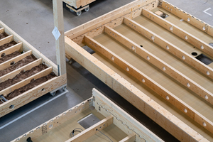  Industriell vorgefertigte Deckenelemente aus Furnierschichtholz mit präzise gefrästen Öffnungen und integrierter Dämmung zeigen den hohen Vorfertigungsgrad des Systems 