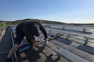  Die Schienen für die Unterkonstruktion der Solaranlage werden mithilfe von geeigneten Haltern und Schrauben auf der Solar-Trägerstütze angebracht 