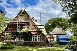 Das Haupthaus ist ein traufständig zur Straße stehender Zweiständerbau mit Fachwerk, Backsteinausfachung und Walmdach 