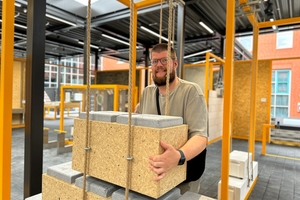  Besucherinnen und Besucher der Ausstellung können an interaktiven Stationen ausprobieren, wie schwer verschiedene Baustoffe zu heben sind 