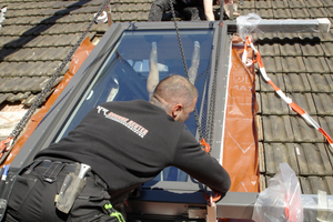  Nachdem sie das Fenster auf den Rahmen gesetzt und die Abstände geprüft hatten, montierten die Dachdecker den Eindeckrahmen 