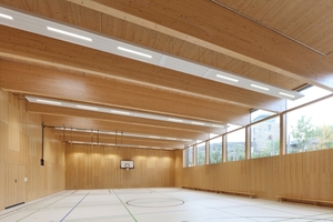  Die Sporthalle der Schule in Darmstadt verfügt über ein Dachtragwerk aus Brettschichtholzträgern, das durch Brettsperrholzelemente für Wände und Decken ergänzt wird 