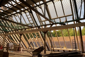 Die vier Dachfelder für jeweils zehn Dachfenster werden von großen Rahmen mit Wechseln aus Holzleimbindern gebildet 