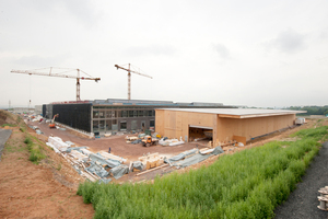  Rechts im Bild gut zu sehen die temporäre Fabrik, in der vor Ort alle Dach- und Wandelemente produziert wurden. Sie bietet ideale Bedingungen für die Vorfertigung 