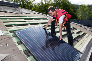  Die Montage des Easy-In Indach-Solarsystems beginnt mit dem Auflegen des ersten Solarmoduls links unten. Dabei wäre es auch möglich, die Montage auf der anderen Seite der Anlage zu beginnen. Das erste Modul wird positioniert und dabei mit dem oberen Ende in die Dachlattung eingehängt
 