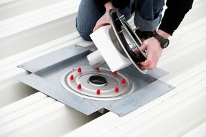  Ein Handwerker setzt einen modifizierten Spin-Ablauf in ein Trapezdach ein 