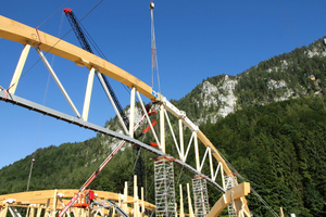  Spektakuläres Manöver: Zwei je 600 t schwere, 75 m weit ausladende Raupenkräne heben die beiden Hälften des Fachwerkträgers in Position, dann werden Ober- und Untergurt verbunden
 