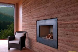  Mitten im Gebäude steht eine dekorative Stampflehmwand, in deren Kern warmwasserführende Heizrohre integriert wurden 