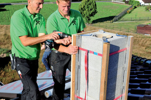  Die Handwerker schrauben die Platten zur Verkleidung des Schornsteines an die Kanthölzer 