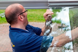  Nach der Anbringung des Aluminium-Gerüstes werden die Glasscheiben in die Führungsschienen eingeschoben 