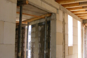  Die HTS-Träger liegen auf dem Kalksteinmauerwerk am Übergang zum Bestandsbau auf. Sie bestehen aus einem Wellstahl-Steg und einem Unter-/ Obergurt aus Holz 