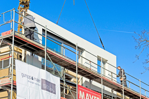  Montage auf der Baustelle, hier in Augsburg. Die vorgefertigten Elemente werden an der vorbereiteten Fassade eingefädelt
 