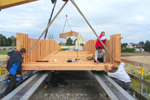  Die vorgefertigten Holzelemente werden auf die Spannbänder gesetzt und verschraubt.  