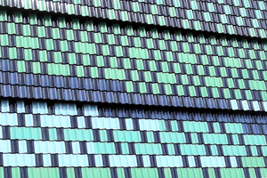  An der Fassade des Schulgebäudes hängen die Dachziegel nahezu senkrecht. Jeder Ziegel ist daher durch das eigens hierfür vorgesehene Nagelloch an der Traglattung verschraubt worden 