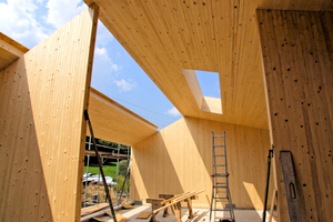  Blick in das Haus von Innen während der Montage. Zu sehen sind die unterschiedlichen Wand- und Deckenstärken der Brettstapel-elemente. Das Holz im Innern bleibt sichtbar 