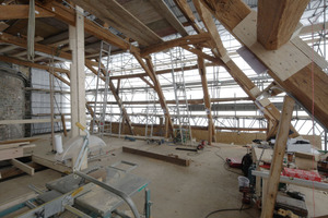  Die Einhausung des Daches wirkt nicht zuletzt durch ihre lichte Höhe wie eine richtige Werkshalle, mit Handwerksgerätschaften, wie z.B. der Kreissäge. Rechts der Westturm des Domes  