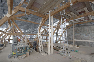  Die Einhausung des Daches wirkt nicht zuletzt durch ihre lichte Höhe wie eine richtige Werkshalle, mit Handwerksgerätschaften, wie z.B. der Kreissäge. Rechts der Westturm des Domes  