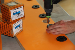  Die Plastikeinsätze für die Kickerstangen werden angeschraubt
 