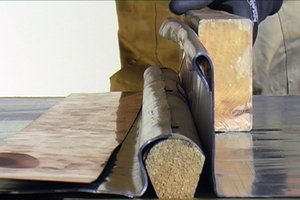  Mit Hilfe des Treibholzes wird zunächst das innenliegende Blech bis zur Mitte um das Holz herumgeführt. Das außenliegende Blech wird einmal in sich umgeschlagen und dann ebenfalls um das Holz herumgeführt 