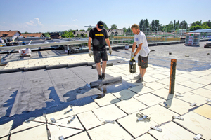  Die erste Lage der Abdichtung mit Polymerbitumenbahnen wird im Gießverfahren vollflächig mit dem Dämmstoff verklebt. Es folgt eine zweite Lage, die mit dem Gasbrenner verschweißt wird Foto: Puren 