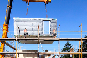  Die Außenwandseiten der Raummodule erhalten werkseitig eine 24 cm dicke Dämmschicht aus Mineralwolle. Darin werden auch die Fenster werkseitig integriert. Nur die Montage der Fassadenbekleidung erfolgt erst nachdem alle Module gesetzt sind Foto: LiWood /  