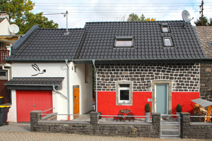  Rechts: Dieselbe Doppelhaushälfte nach der Sanierung und Eindeckung mit schwarz engobierten Ziegeln Foto: Thomas Wieckhorst 