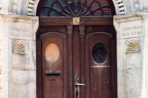  Verwirrend: Das historische Portal ist älter als die Tür mit Art-Deco-Anklängen. Das Oberlicht ist in Jugendstilformen gestaltet 