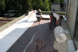  Jetzt kann der Aufbau des eigentlichen Gründachs beginnen: Auf einer mit Kiesfangleiste abgetrennten Teilfläche verlegen die Dachhandwerker Schutzvlies und Dränageplatten aus EPS  