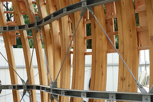  Die Stahlringe wurden über eingelassene Rampa-Muffen und Schlüsselschrauben an die BS-Holz-Spanten angeschlossen. Ein System aus fachwerkartig angeordneten Stahlzugstangen überträgt die Lasten der Konstruktion in den Fundamentring Foto: Timber Concept Gmb 