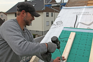  Hier befestigt ein Dachhandwerker die Dämmelemente über die Konterlattung lagesicher auf den Sparren Foto: Braas 