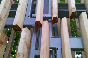  Detailansicht der Holzlamellen auf Stahlkonstruktion: Die unterschiedlichen Anschlusshöhen der Stahlrahmen sind zu sehen, außerdem die Konsolenkonstruktion 