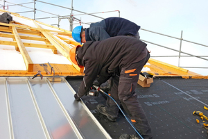  Die Dachdecker der Bühler AG befestigen das Edelstahl-Stehfalz-Blech auf der Unterkonstruktion  Foto: Bühler Bedachungen AG 