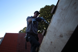  Dachdeckermeister Jan Stüker bereitet das Dach für die Montage eines Dachfensters vor 