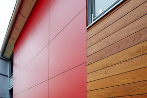  An der Fassade wurde eine Kombination aus witterungsbeständigen Eichendielen mit leuchtend roten Fassadentafeln montiert Foto: Rockwool 
